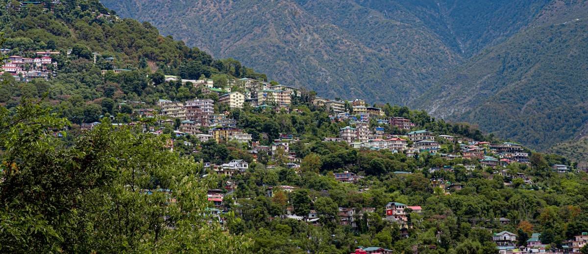 Dharamshala town spread across the Himalayan hillside, Himachal Pradesh — one-way taxi drop with House of Taxi